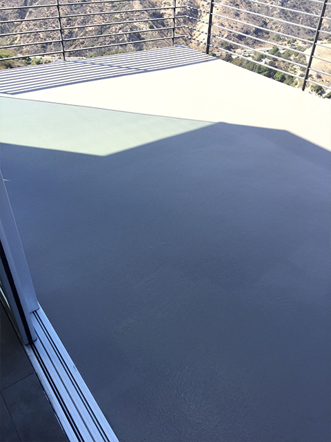 Worker applying balcony coating with roller